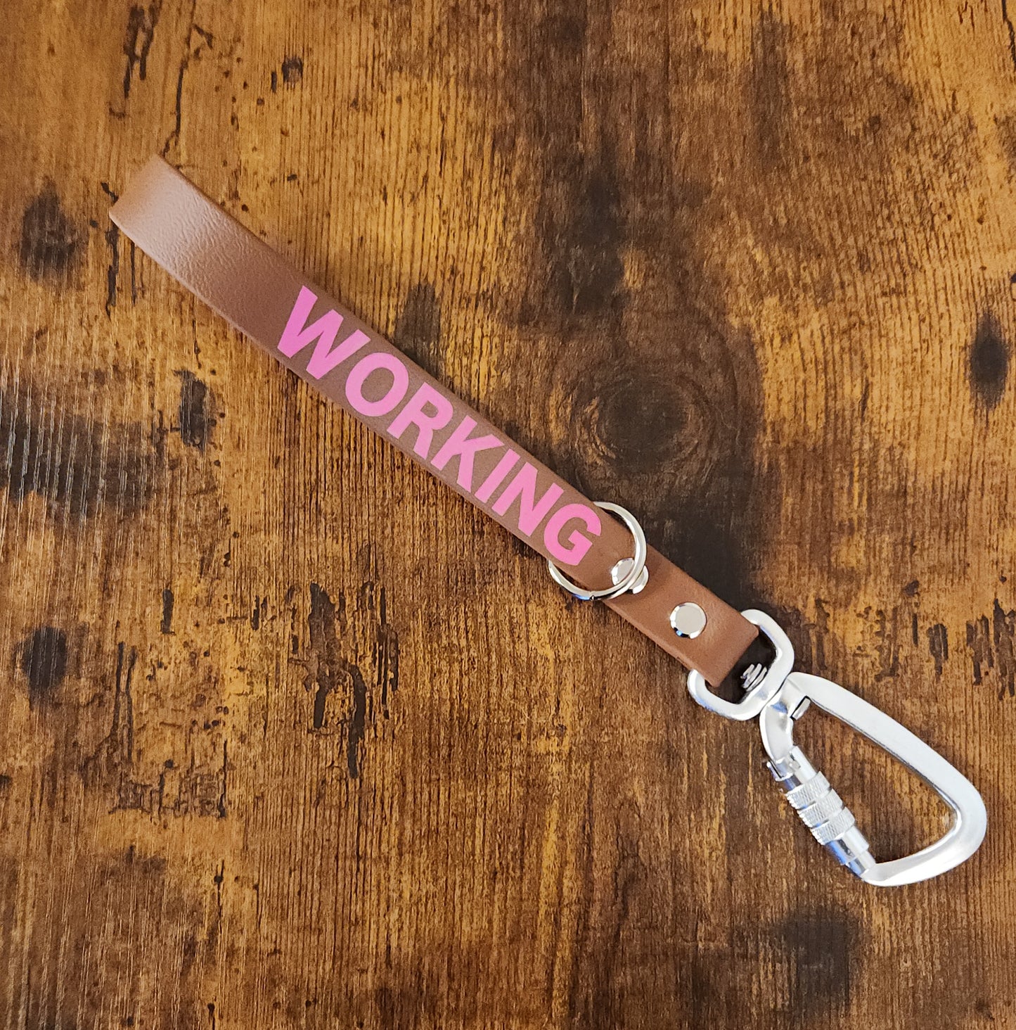 brown biothane traffic lead reading "WORKING" with floating o ring and twist lock carabiner