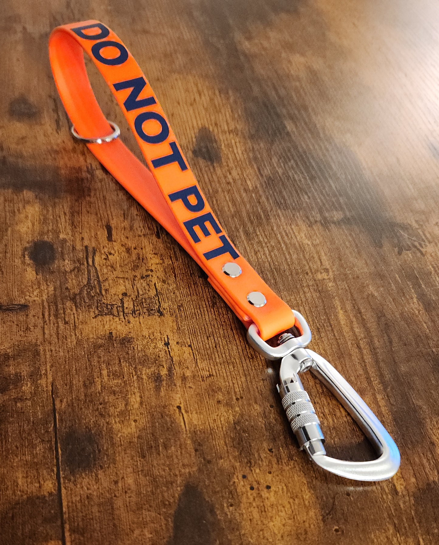 orange biothane traffic handle with dark blue text reading "DO NOT PET" and a twist-lock carabiner clip