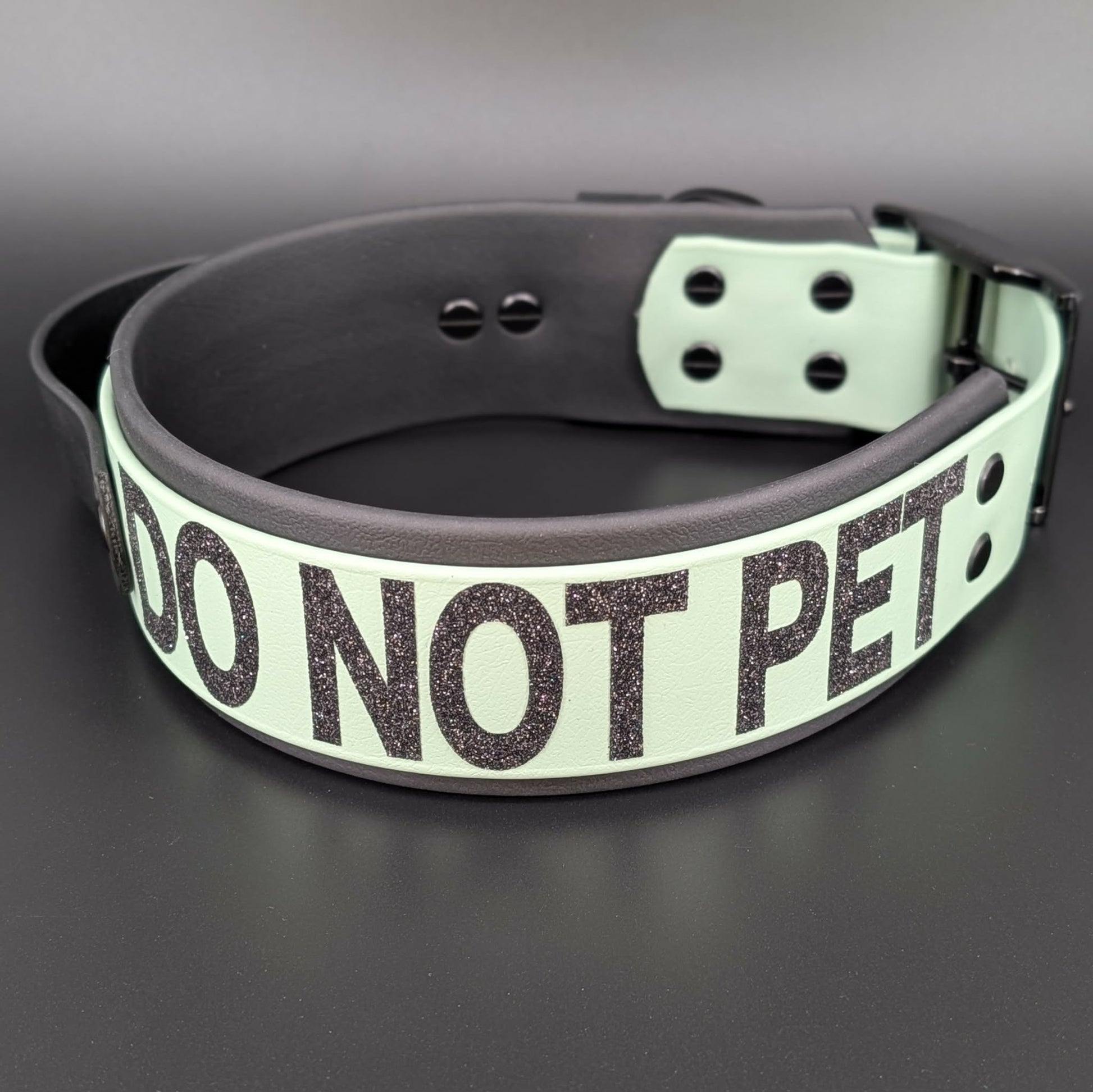 2 inch wide black and sage green layered biothane dog collar with tactical handle and do not pet text in black glitter
