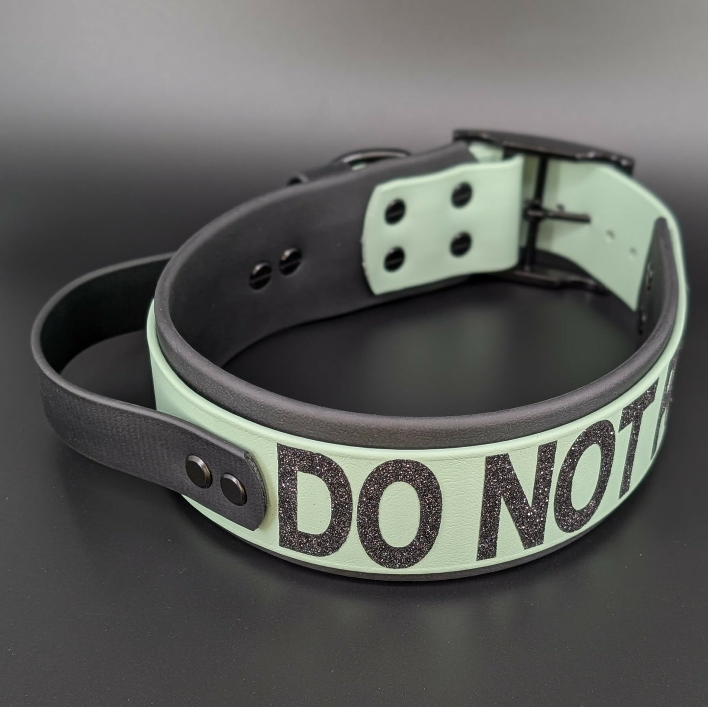 2 inch wide black and sage green layered biothane dog collar with tactical handle and do not pet text