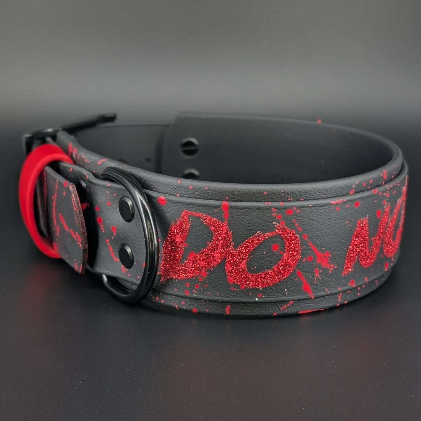 2 inch wide black layered biothane dog collar with black hardware and red glitter do not pet text with red splatter paint