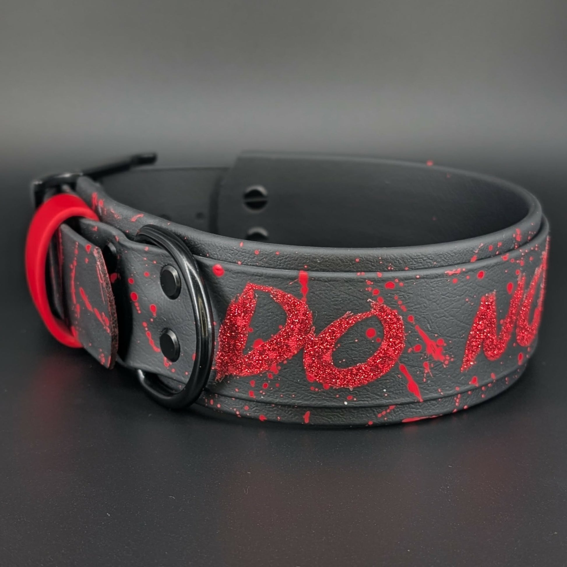 2 inch wide black layered biothane dog collar with black hardware and red glitter do not pet text with red splatter paint