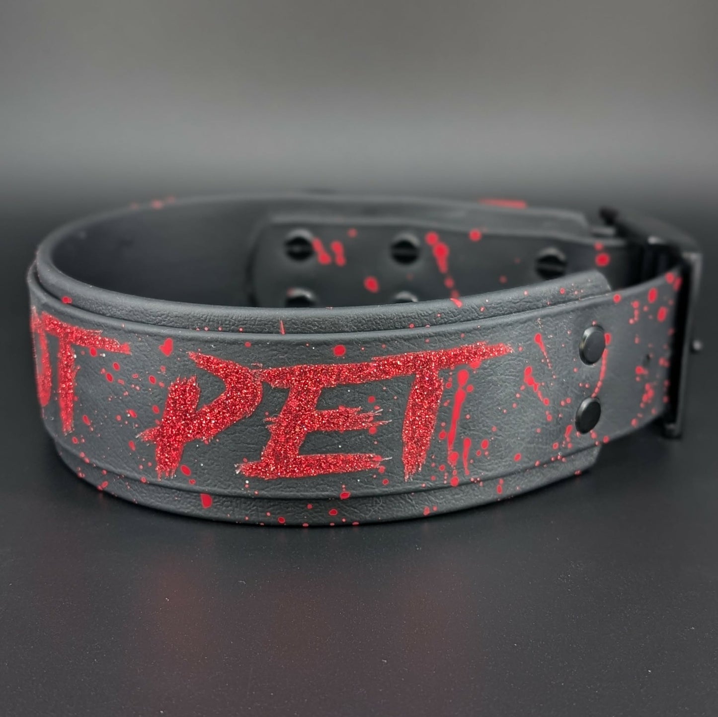 2 inch wide black layered biothane dog collar with black hardware and red glitter do not pet text