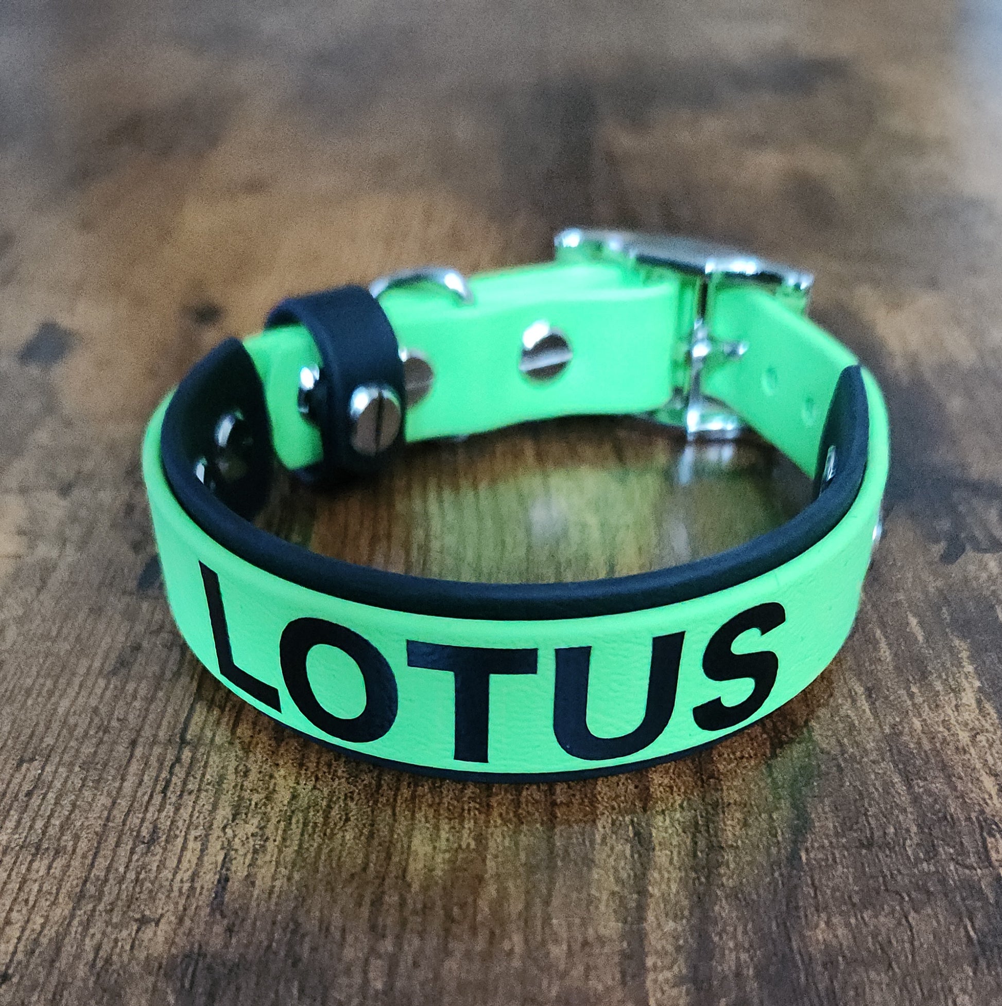 black and light green layered biothane dog collar reading "LOTUS"