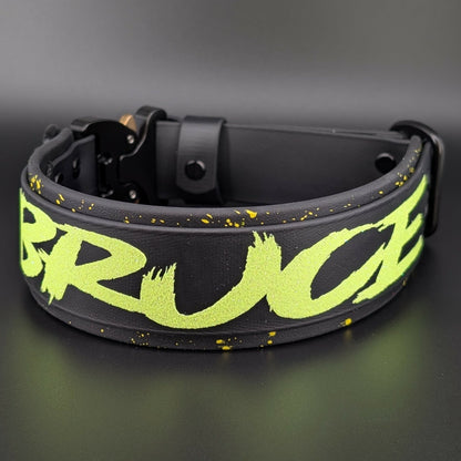 black layered biothane dog collar with yellow splatter paint and custom text with a quick release cobra buckle