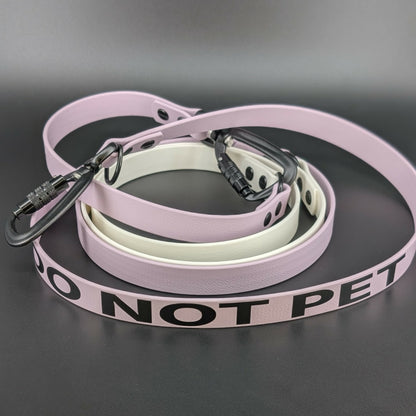 convertible over the shoulder hands free dog leash made from white and lavender biothane with do not pet text and auto locking carabiner clips