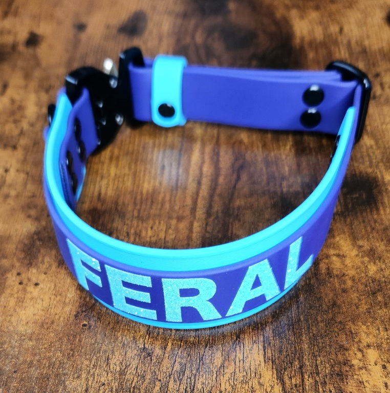 glitter text reading 'FERAL' on layered biothane dog collar with quick release cobra buckle