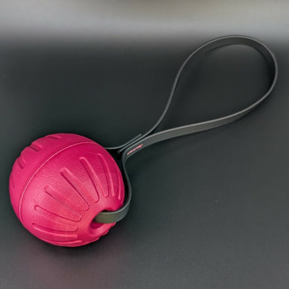large pink Eva foam reward ball tug with black biothane loop handle for dog