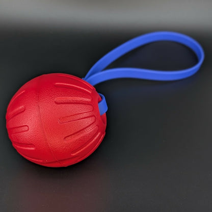 large red eva foam ball tug with a royal blue biothane loop handle