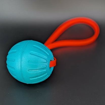 large teal eva foam ball tug with an orange biothane loop handle