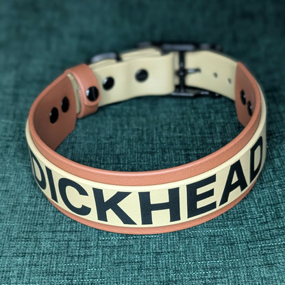 tan and brown layered biothane dog collar with 'DICKHEAD' printed on a textured green background