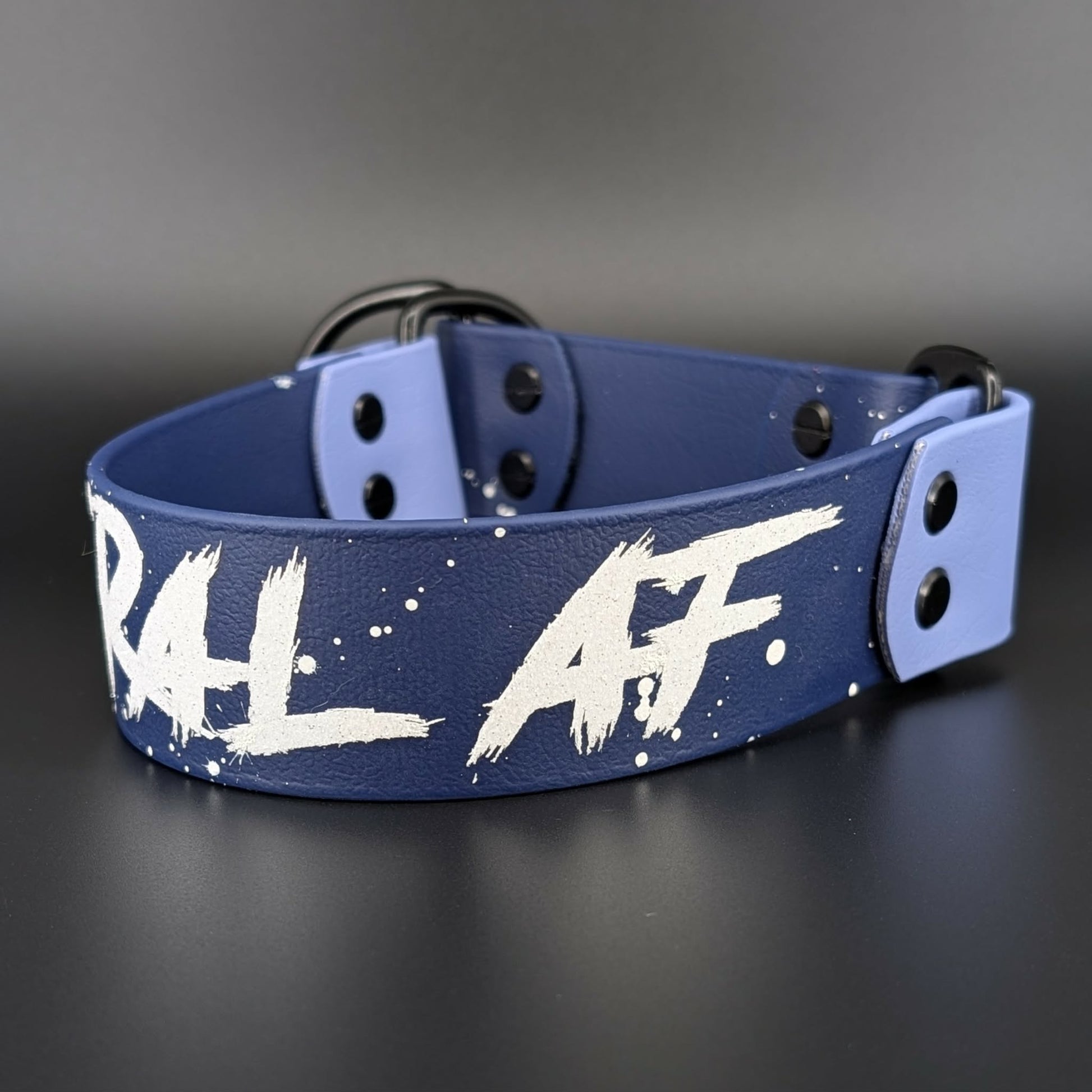 navy blue and periwinkle biothane limited slip collar with splatter paint and glitter feral af text