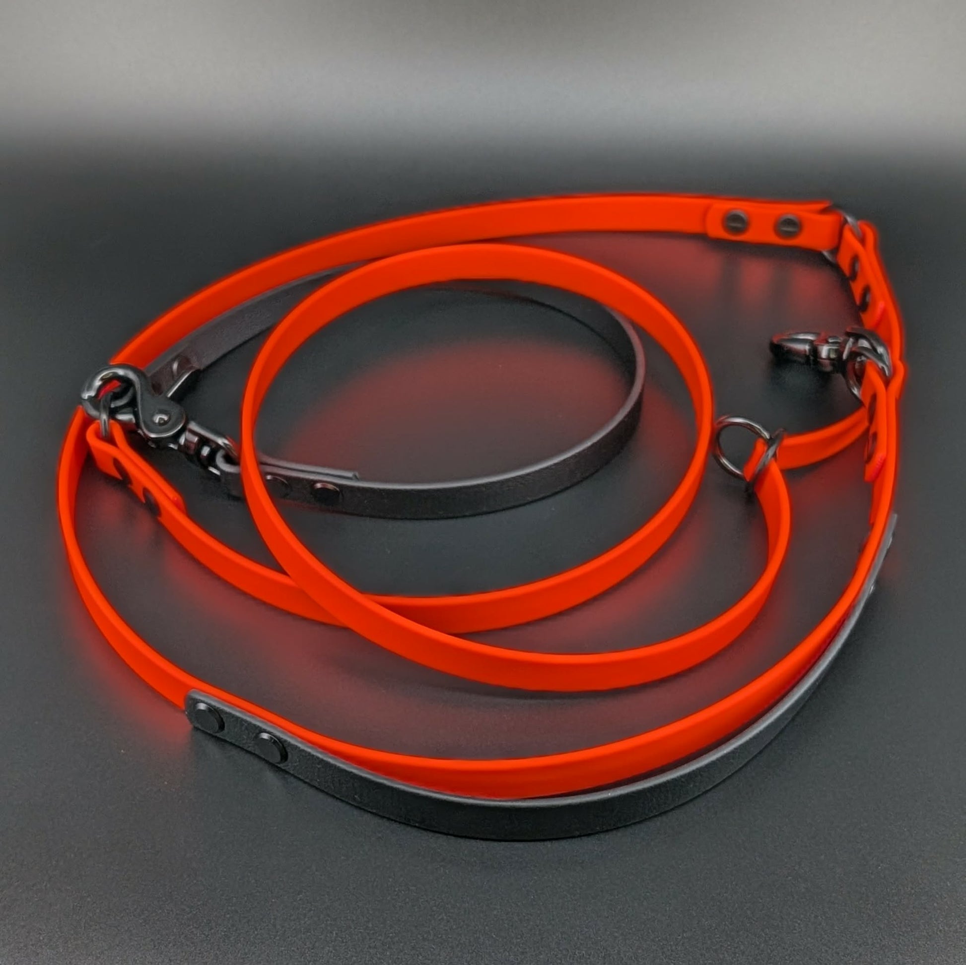 orange and black biothane hands free dog leash with adjustable waist attachment and traffic handle