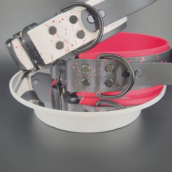 2 inch wide layered biothane dog collars, each with a tactical handle, splatter paint, custom glitter text, and quick release cobra buckle