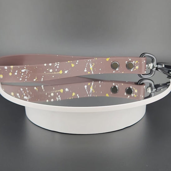 dark brown biothane traffic handle with splatter paint and a black carabiner clip that auto locks and twists to unlock and open