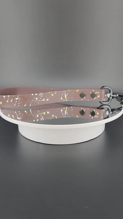 dark brown biothane traffic handle with splatter paint and a black carabiner clip that auto locks and twists to unlock and open