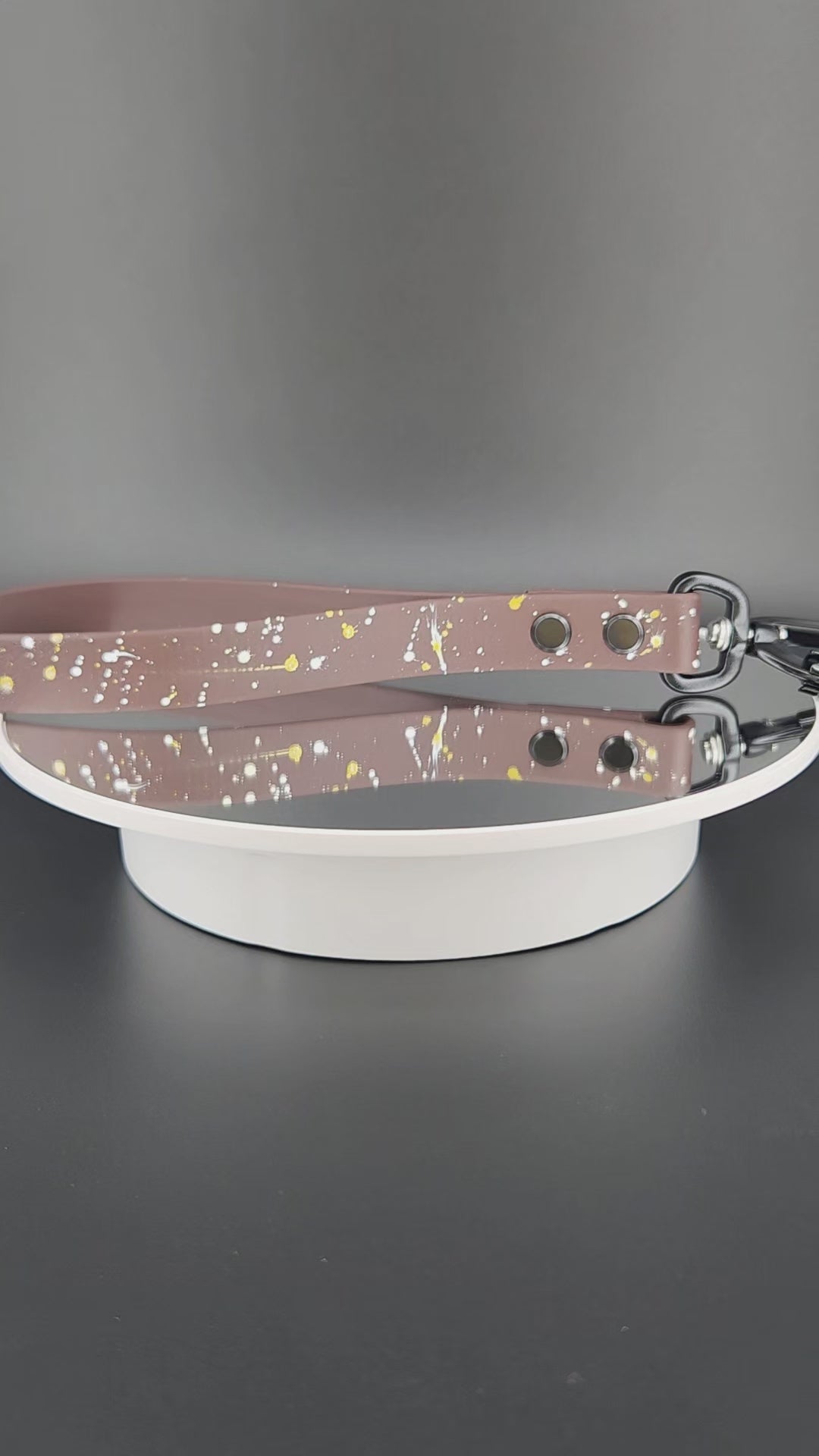 dark brown biothane traffic handle with splatter paint and a black carabiner clip that auto locks and twists to unlock and open