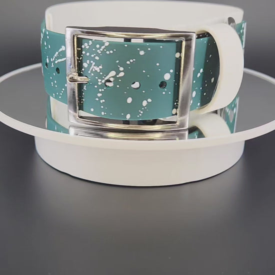 2 inch wide white and dark green layered biothane dog collar with glitter pet your own fucking dog text, white splatter paint, and silver hardware