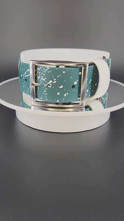 2 inch wide white and dark green layered biothane dog collar with glitter pet your own fucking dog text, white splatter paint, and silver hardware