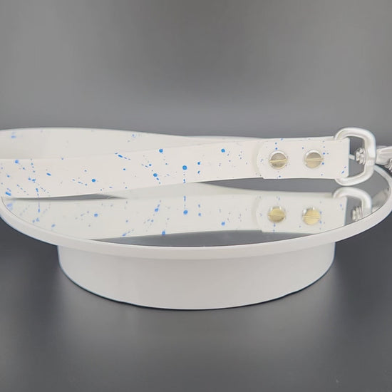 white biothane traffic handle with blue splatter paint and a silver carabiner clip that auto locks and twists to unlock and open