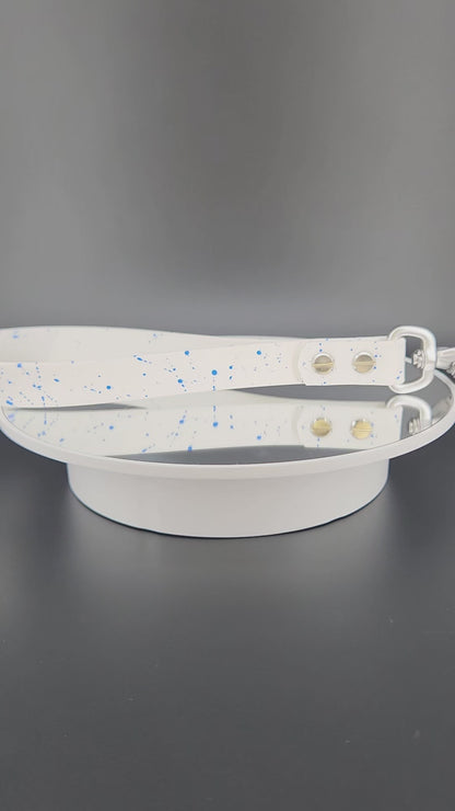 white biothane traffic handle with blue splatter paint and a silver carabiner clip that auto locks and twists to unlock and open